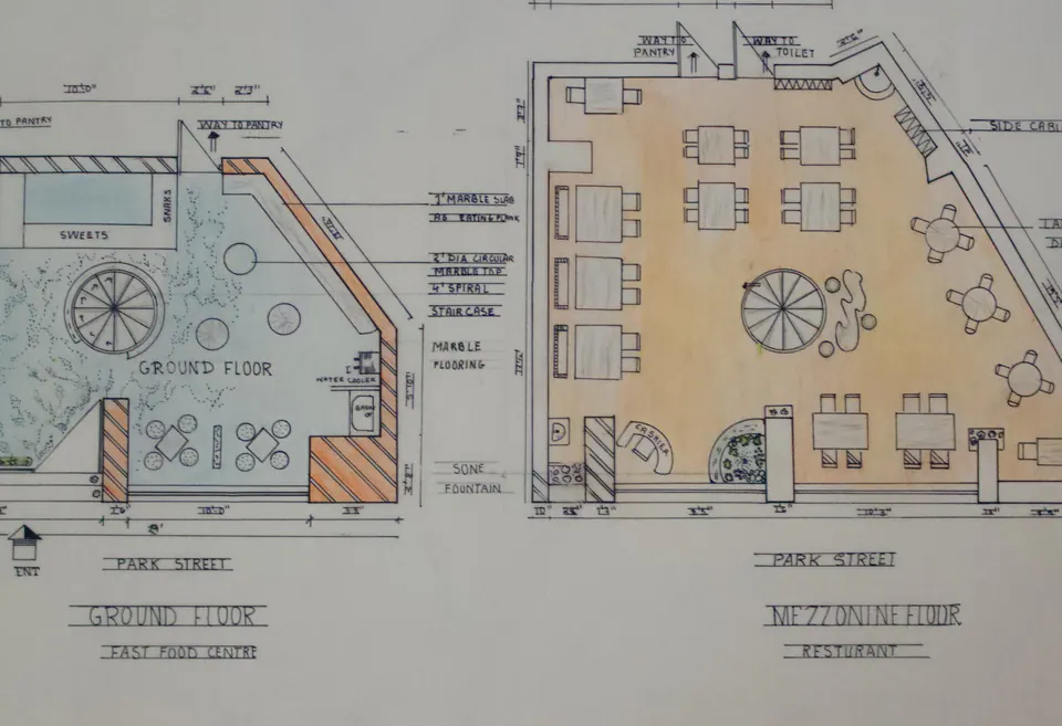 Hand-drawn plans for a fast-food center and restaurant showing seating, counters, rooms, and a central spiral staircase.